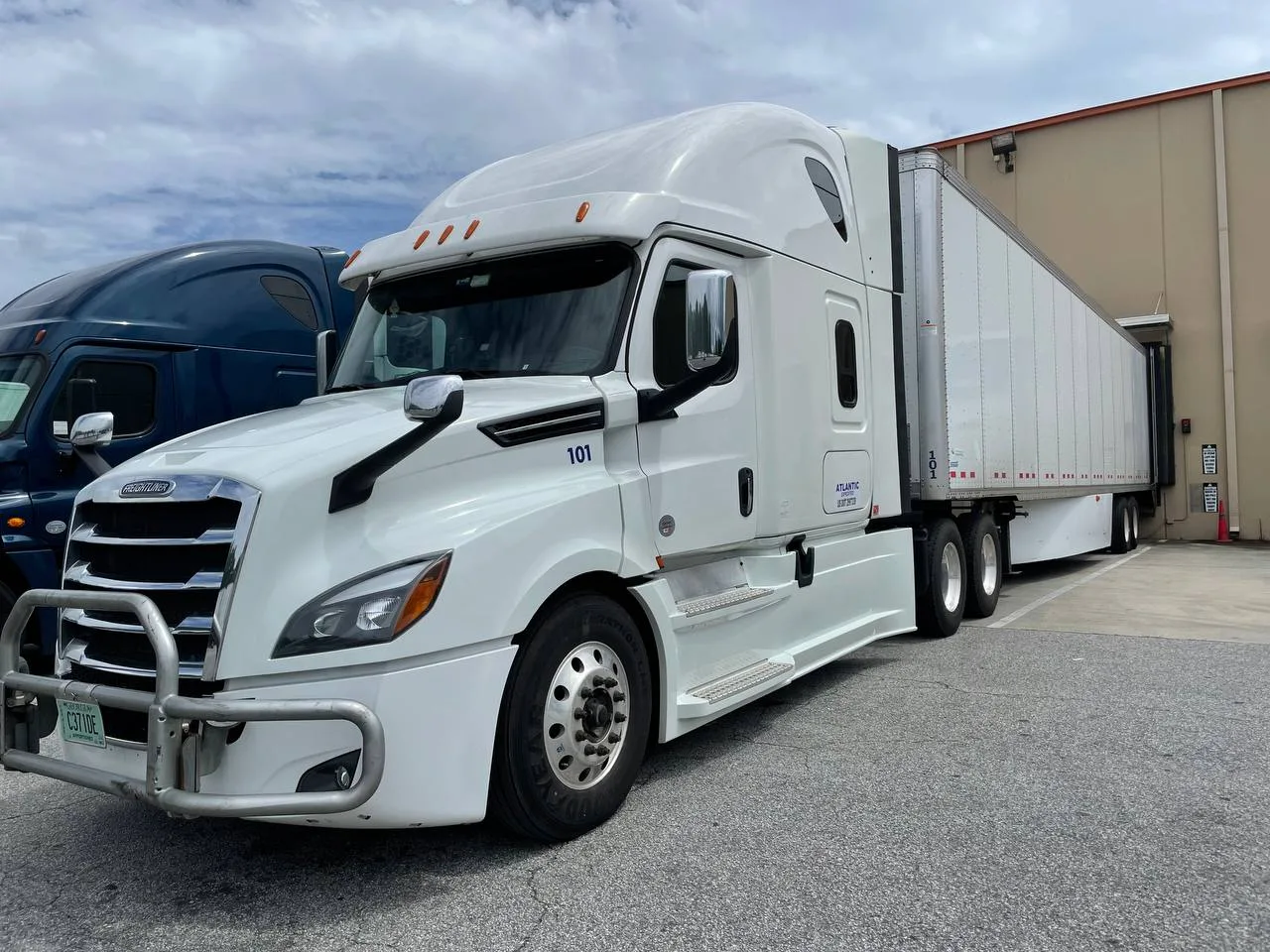Atlantic Expedited tractor with a dry van trailer backed into a loading dock