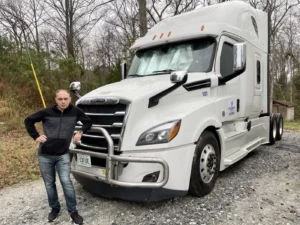 Atlantic Expedited driver Dima beside Cascadia tractor 101